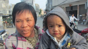 妇人带着孩子上街晒太阳。（中国妇权记者摄）xiao