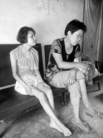 被拉到山西配阴婚的陕西残疾女陈某（左）已回到家中，因为智障，她尚不知道自己经历了一次生死劫难。