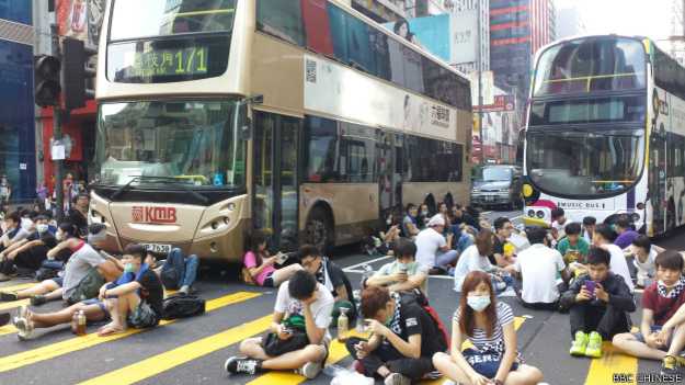 在旺角，示威者坐在马路中间，阻止巴士经过（BBC中文网记者萧尔摄）。