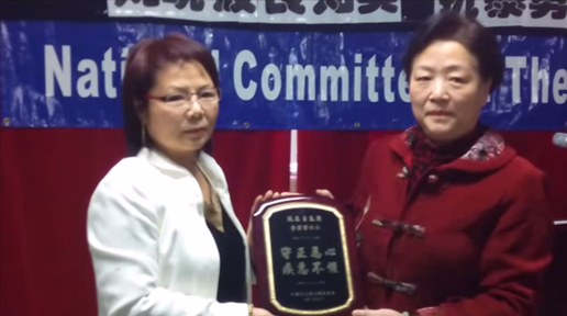 民主党全委会副主席陈立群向李碧云颁奖，中国妇权主席张菁代李碧云领奖。